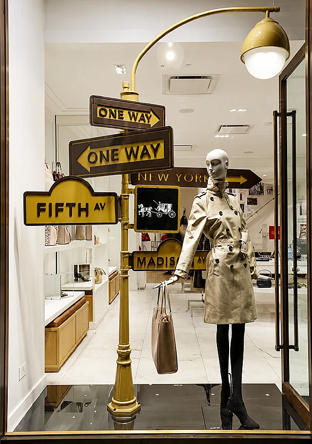 Client-installed retail window display with custom street signs, lighting and mannequin presentation